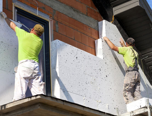 des artisans posent de l'isolation extérieure