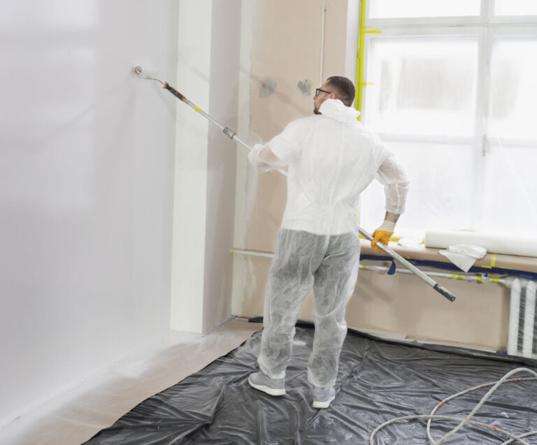 ouvrier peignant un mur interieur